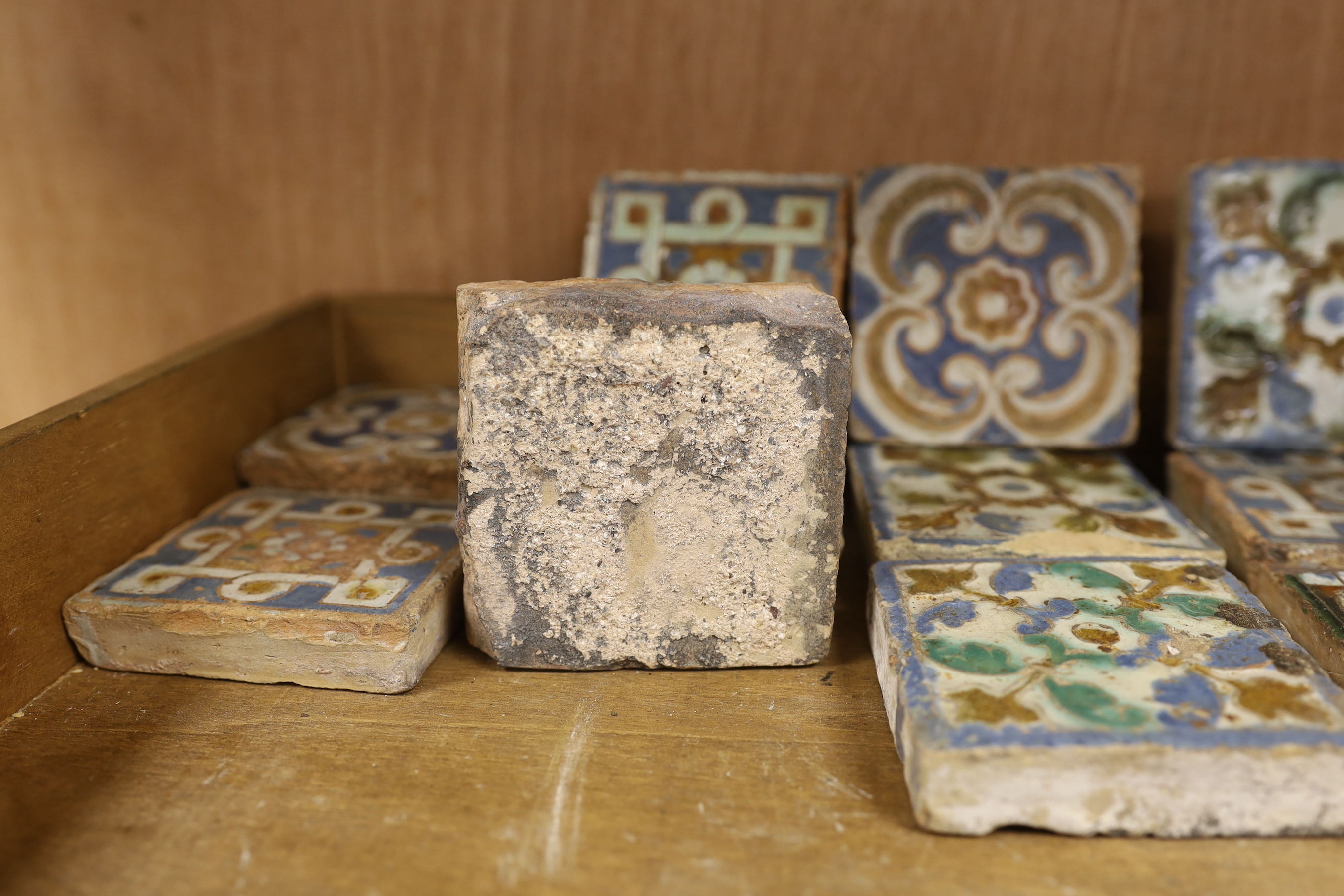 A group of eleven 17th century Spanish polychrome tiles, 8cm square, varying thicknesses